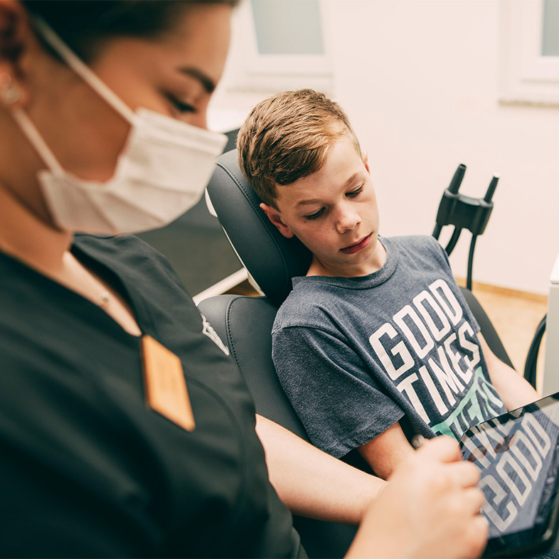 ZFA im Gespräch mit einem jungen Patienten zum Thema Füllungen im Zentrum für Zahnmedizin Dr. Sorg & Kollegen