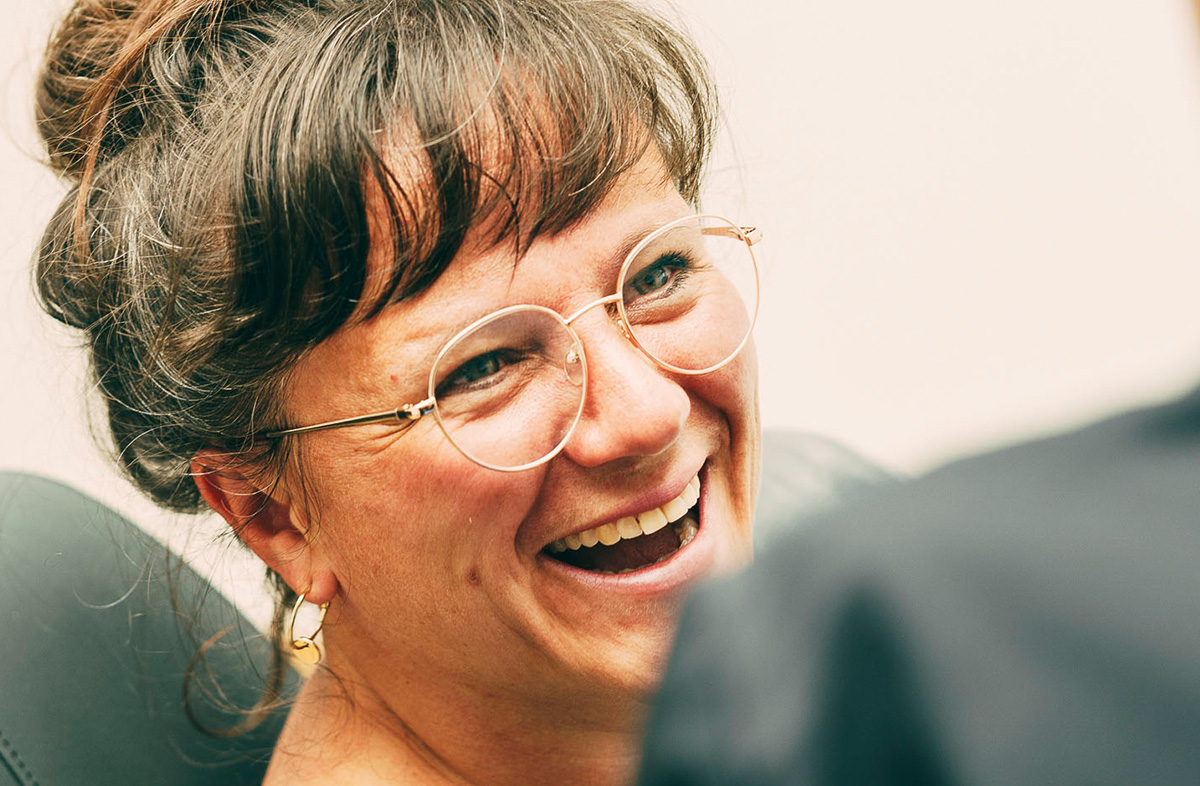 Eine Frau lacht nach einer KFO-Behandlung im Zentrum für Zahnmedizin Dr. Sorg & Kollegen