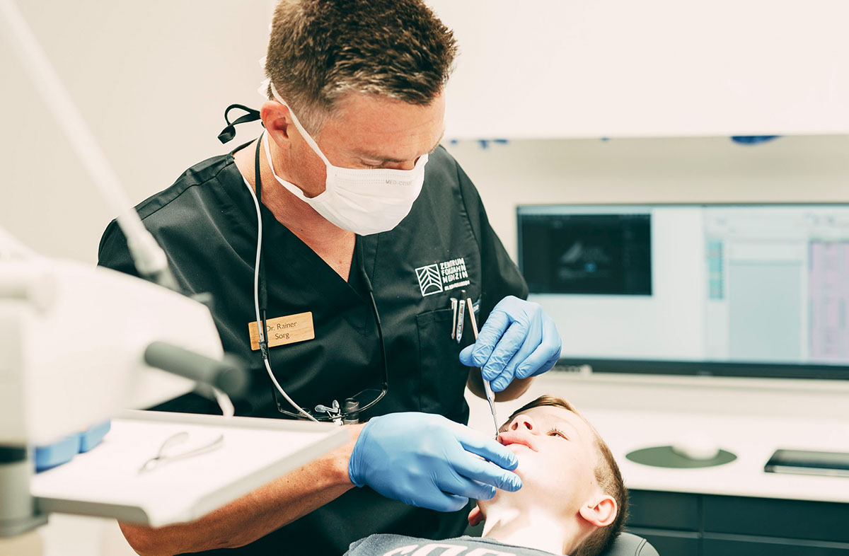 Dr. Sorg in einer Behandlung mit einem Kind im Zentrum für Zahnmedizin Dr. Sorg & Kollegen