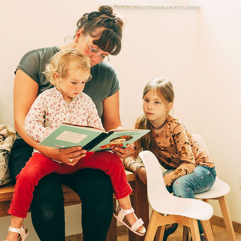 Zwei kleine Kinder warten mit Ihrer Mama im Wartezimmer im Zentrum für Zahnmedizin Dr. Sorg & Kollegen