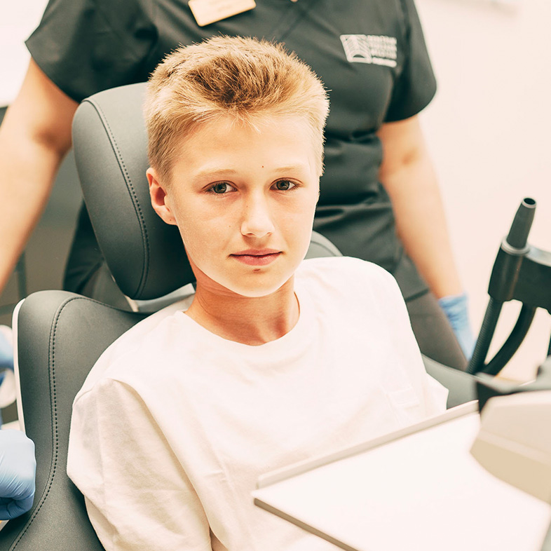 Ein junger Patient auf dem Behandlungsstuhl im Zentrum für Zahnmedizin Dr. Sorg & Kollegen