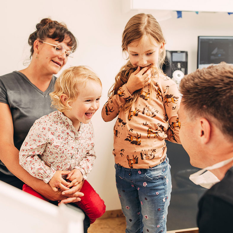 Dr. Sorg macht Quatsch mit zwei jungen Patientinnen und deren Mutter im Zentrum für Zahnmedizin Dr. Sorg & Kollegen