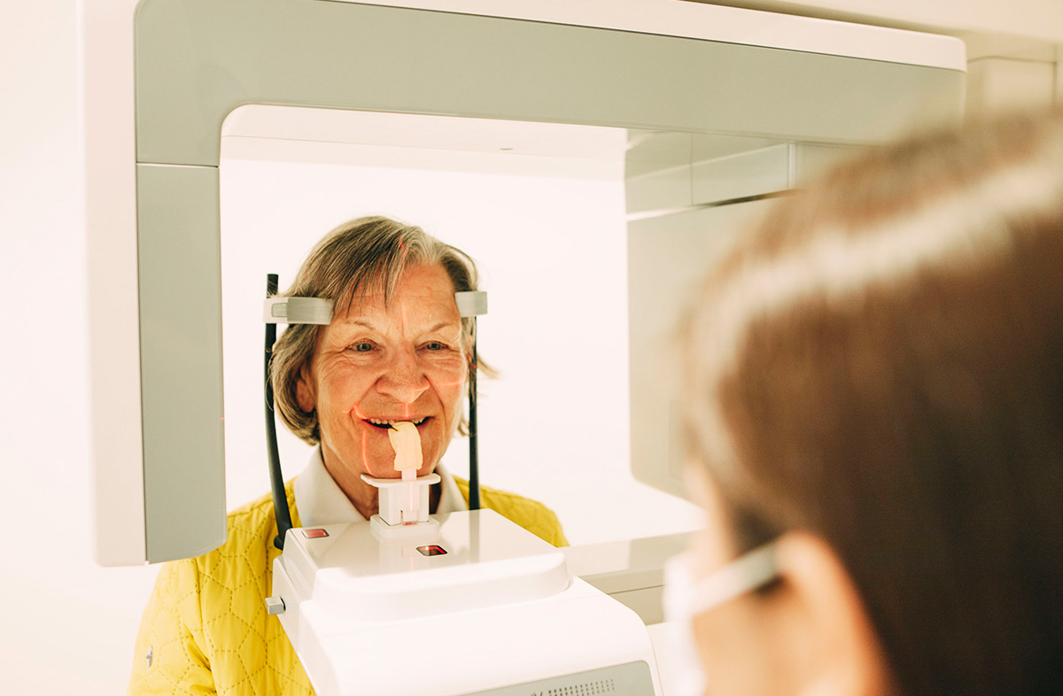 Eine ältere Dame steht im Röntgengerät - auch DVT genannt - im Zentrum für Zahnmedizin Dr. Sorg & Kollegen